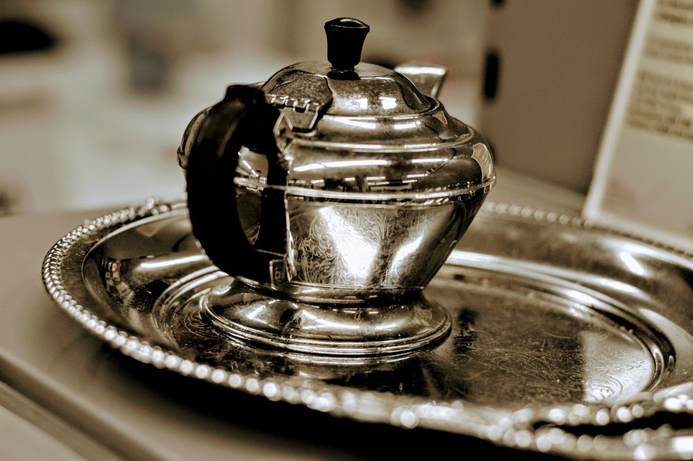 Antique sterling silver tea set laid out for appraisal